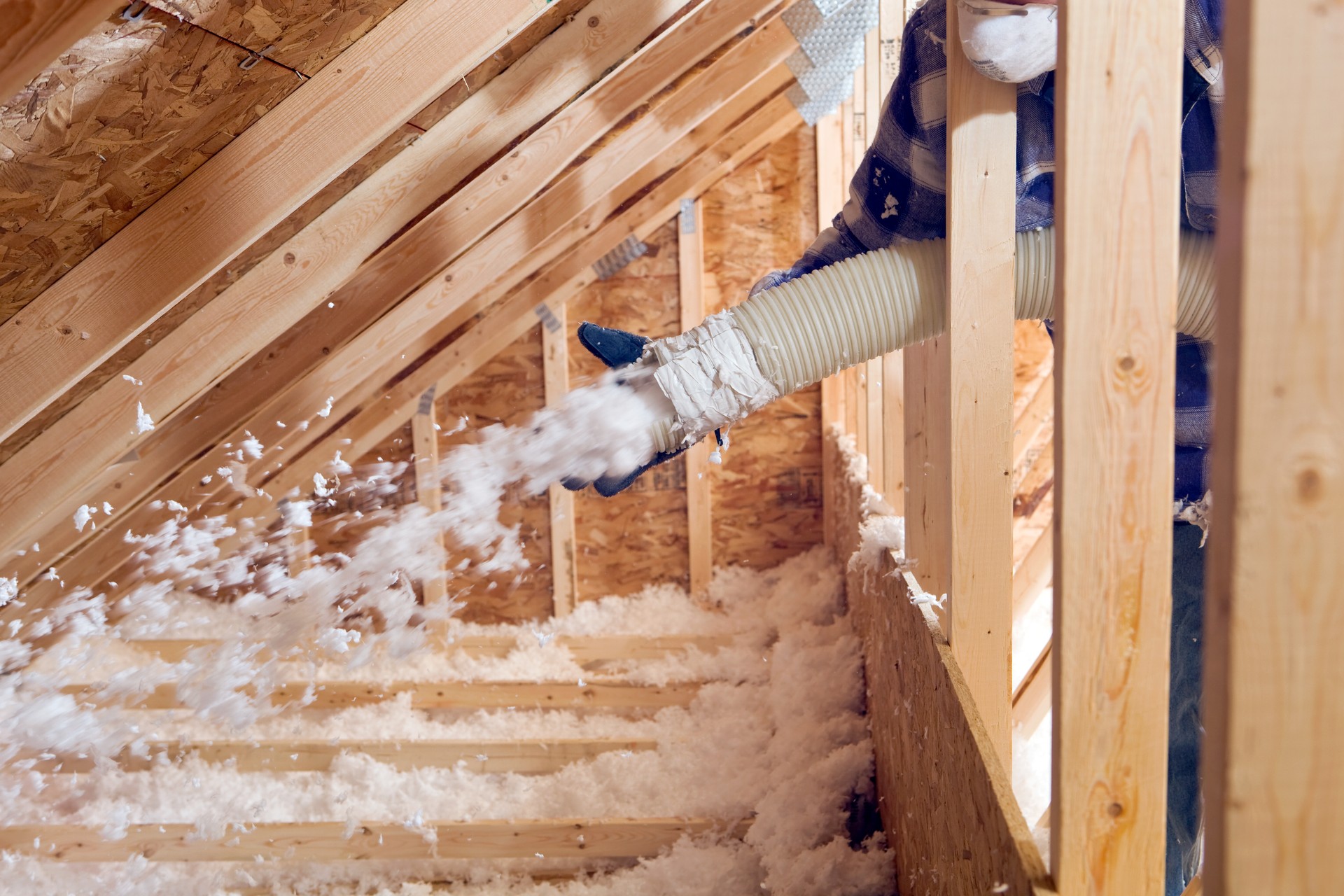  Spraying Blown Fiberglass Insulation between Attic Trusses